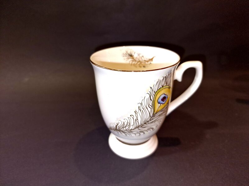 Puodelis su piešiniu plunksna