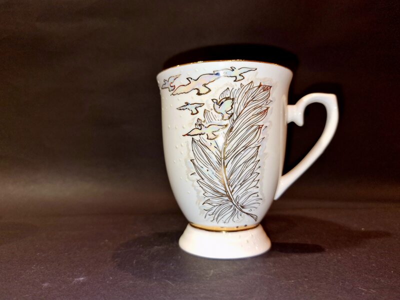 Puodelis su piešiniu plunksna ir paukščiais